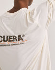 Model wearing Cuera Active Light Weight T-Shirt in Off White/Walnut, close-up detail on model