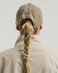 Model wearing Cuera Offcourt Cuera Cap in Walnut, back studio view