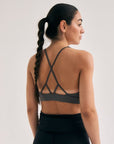 Model wearing Cuera Oncourt Soft Bra Top in Dark Grey, back studio view