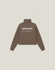 Model wearing Cuera Offcourt Cuera Half Zip Sweat in Walnut, close-up detail on model
