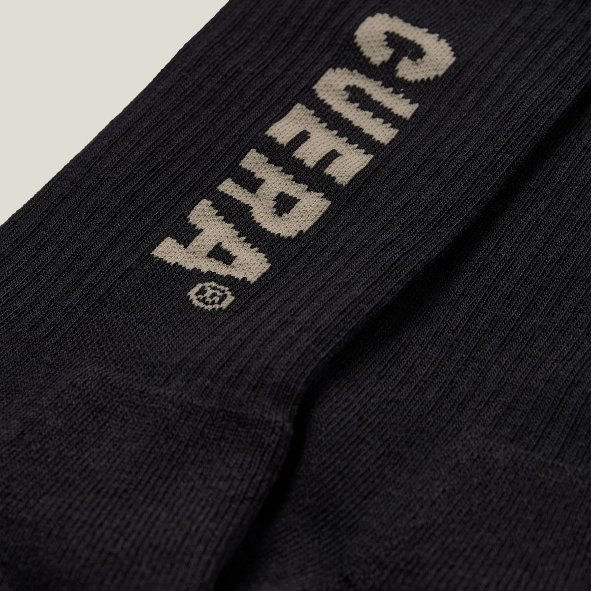 Model wearing Cuera 2-pack Cuera Padel Socks in Black/Sand, front studio view