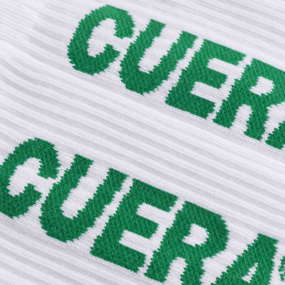 Model wearing Cuera 2-pack Cuera Padel Socks in White/Green, lifestyle action shot on the padel court