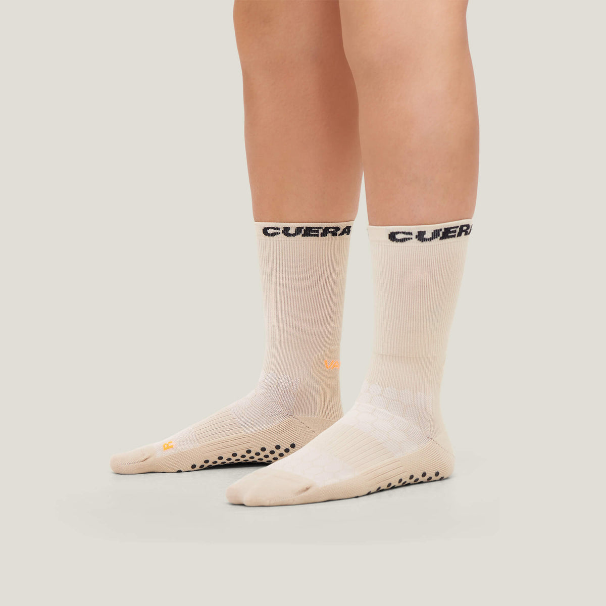 Model wearing Cuera 2-Pack Grip Socks in Sand, back studio view