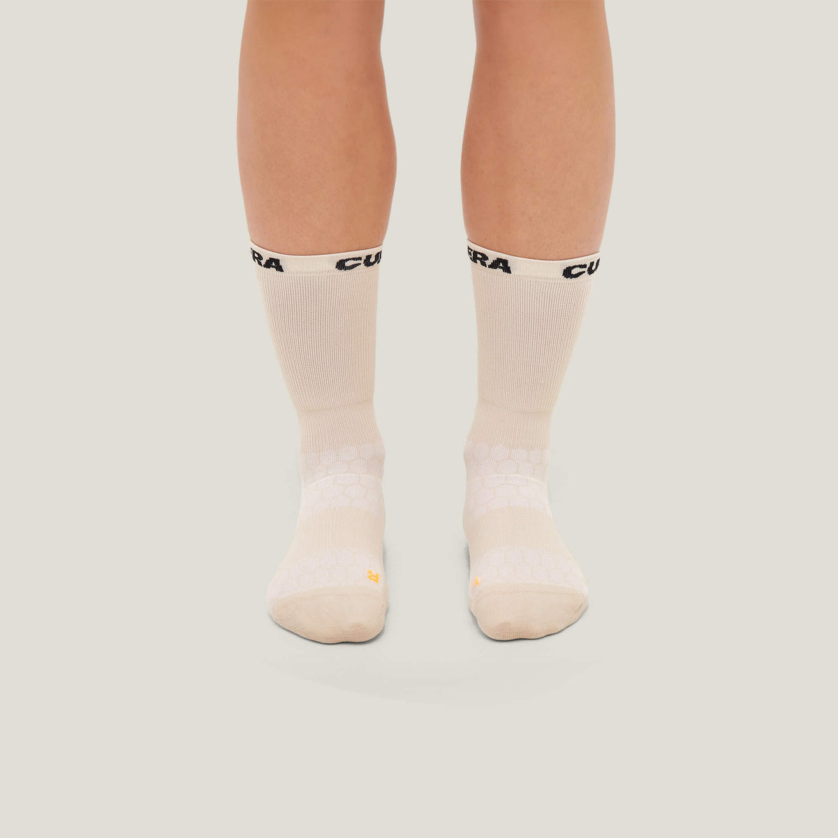 Model wearing Cuera 2-Pack Grip Socks in Sand, front studio view