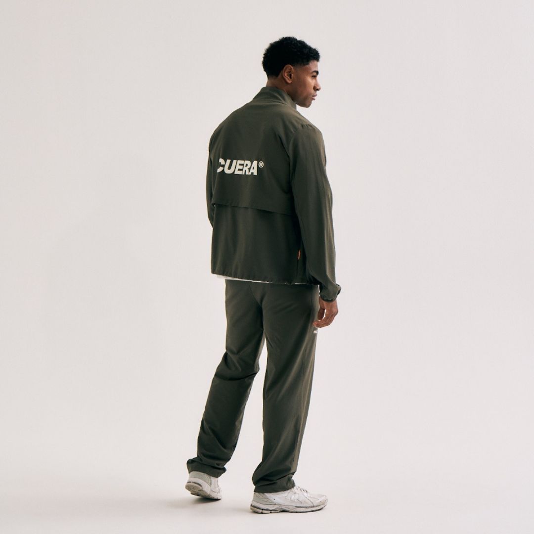 Model wearing Cuera Active Cuera Track Jacket in Army, back studio view