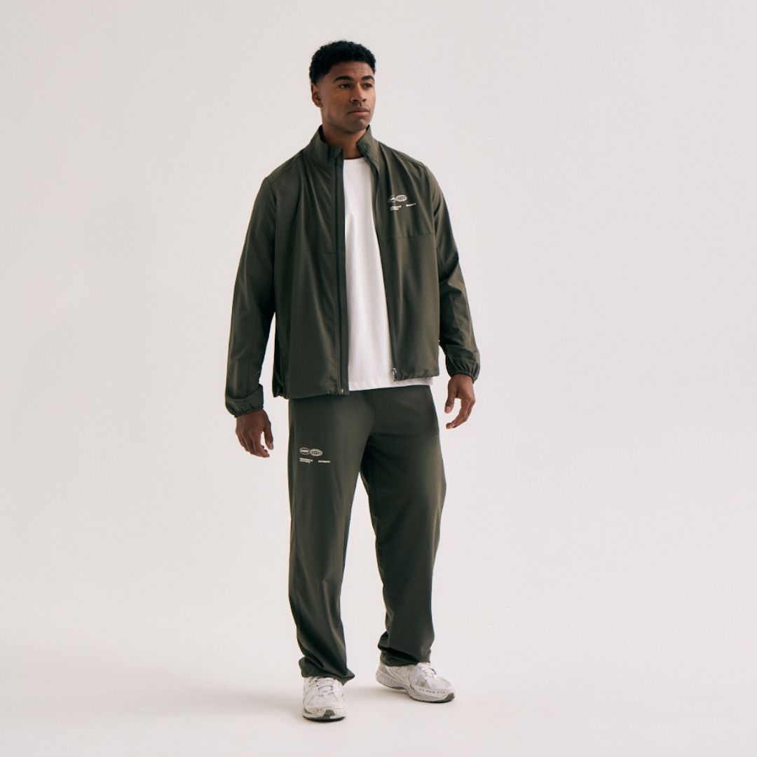 Model wearing Cuera Active Cuera Track Jacket in Army, front studio view
