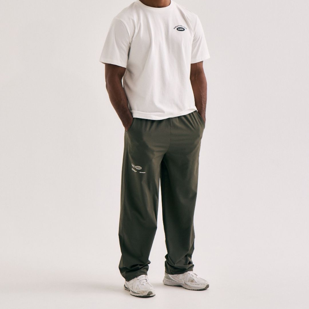 Model wearing Cuera Active Cuera Track Pants in Army, front studio view