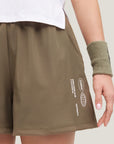 Woman wearing Cuera Womens Active Globe Shorts in Walnut, close-up detail on model