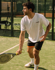 Model wearing Cuera Active Light Weight T-Shirt in White, lifestyle action shot on the padel court