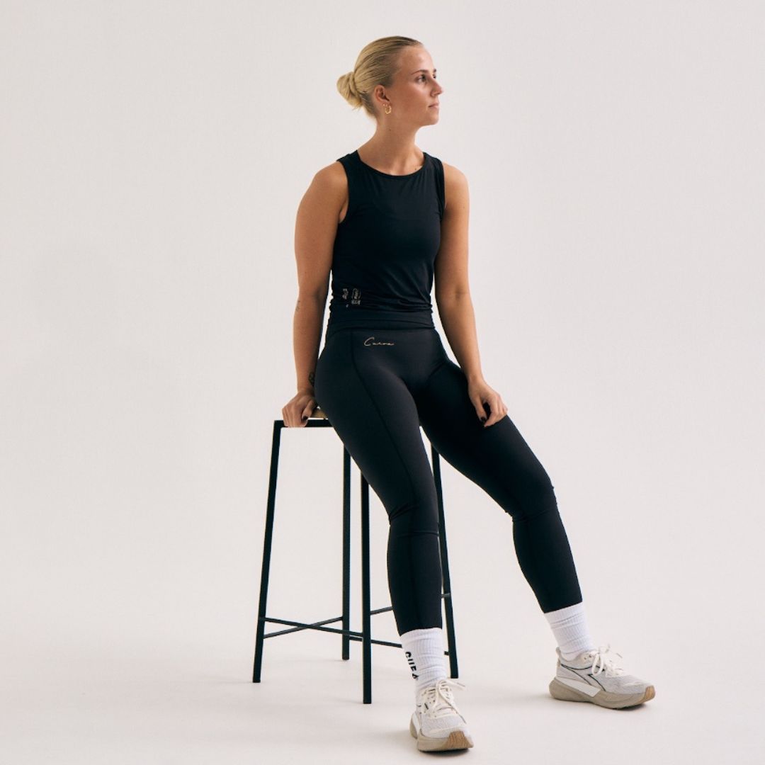 Model wearing Cuera Active Logo Tights Long in Black, front studio view