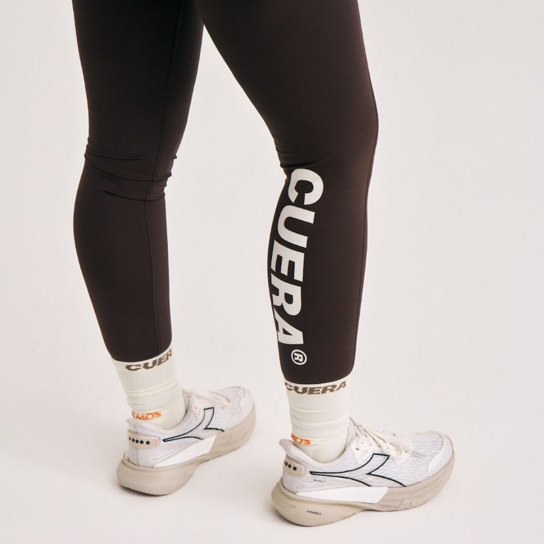 Model wearing Cuera Active Logo Tights Long in Dark Brown, close-up detail on model
