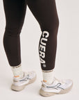 Model wearing Cuera Active Logo Tights Long in Dark Brown, close-up detail on model