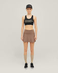 Woman wearing Cuera Active Made Bra in Black with matching skirt, front studio view