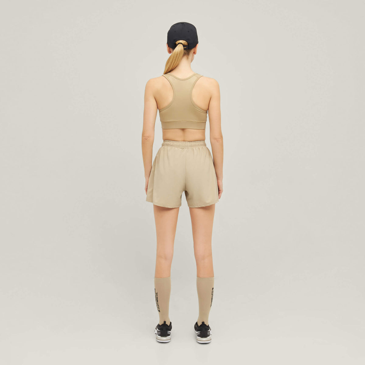 Woman wearing Cuera Active Made Bra in Grey, back studio view