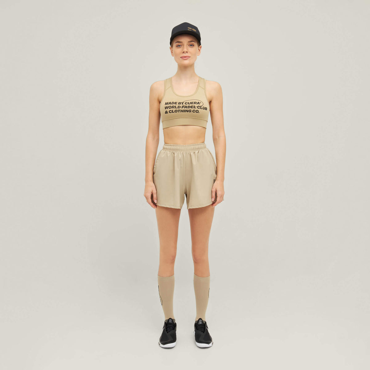 Woman wearing Cuera Active Made Bra in Grey with matching shorts, front studio view
