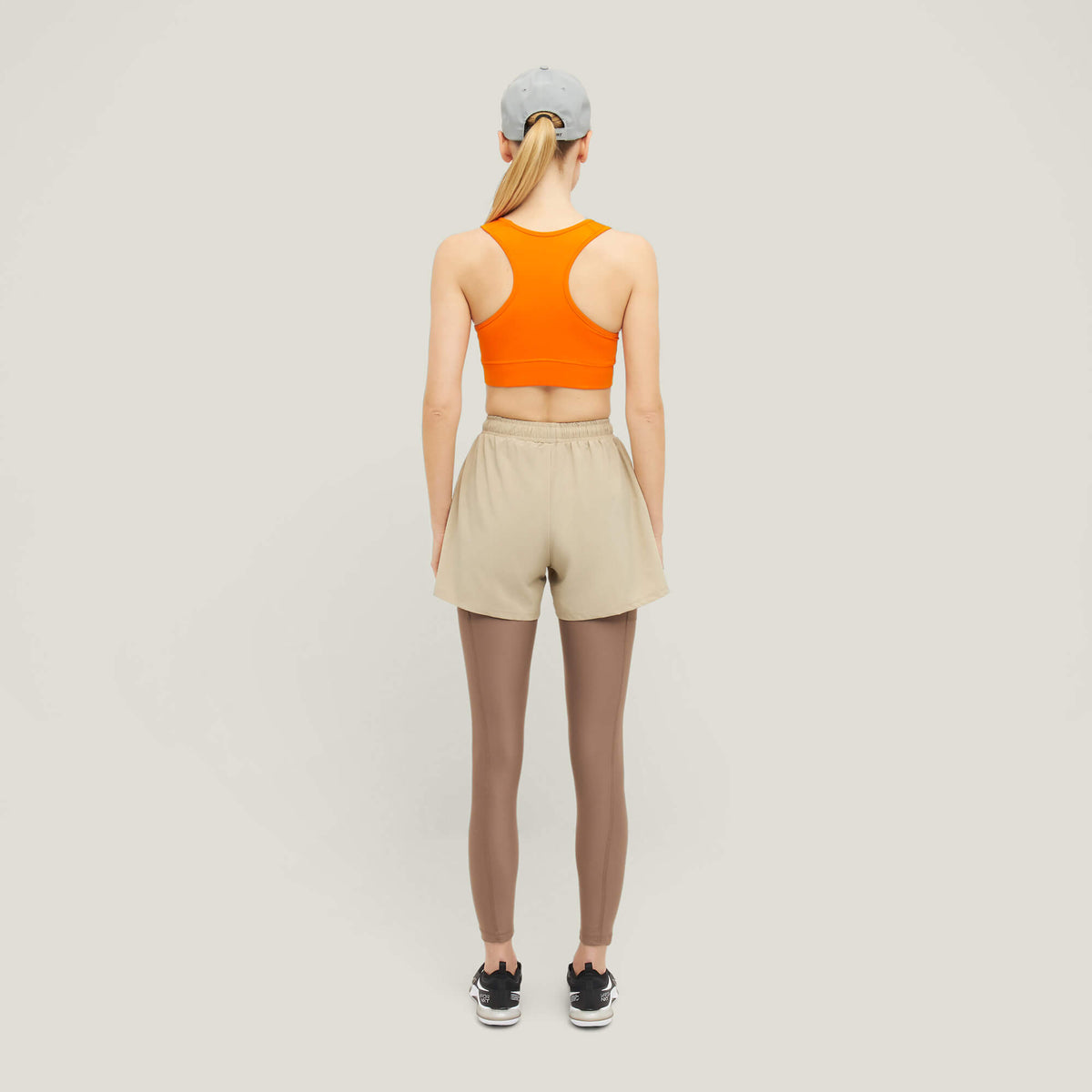 Woman wearing Cuera Active Made Bra in Orange, back studio view