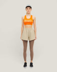 Woman wearing Cuera Active Made Bra in Orange with matching shorts, front studio view