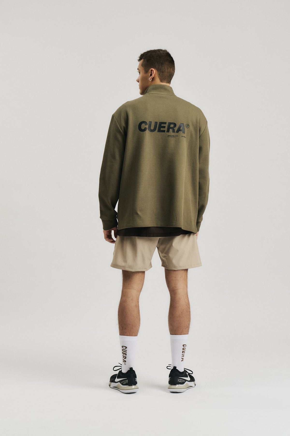 Model wearing Cuera Active Structure Half Zip in Army, back studio view