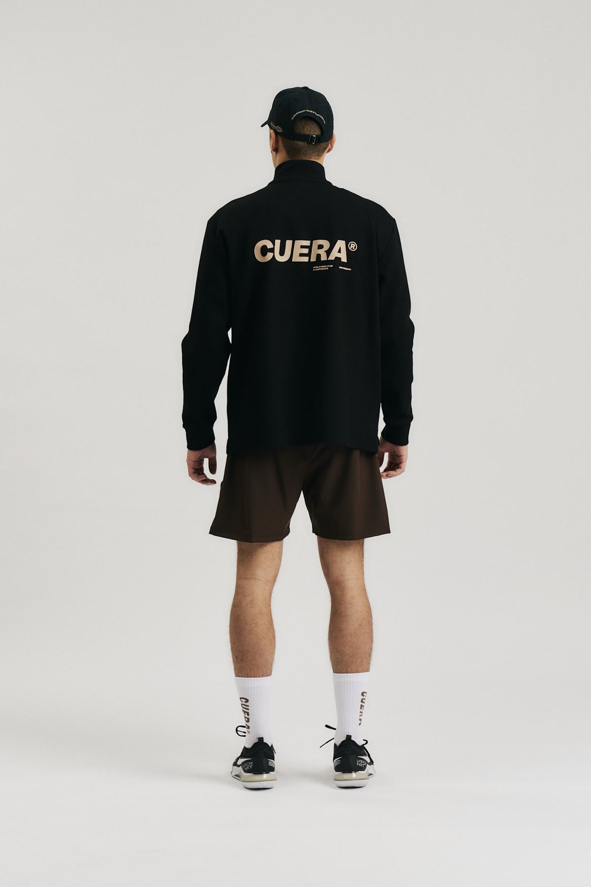 Model wearing Cuera Active Structure Half Zip in Black, back studio view