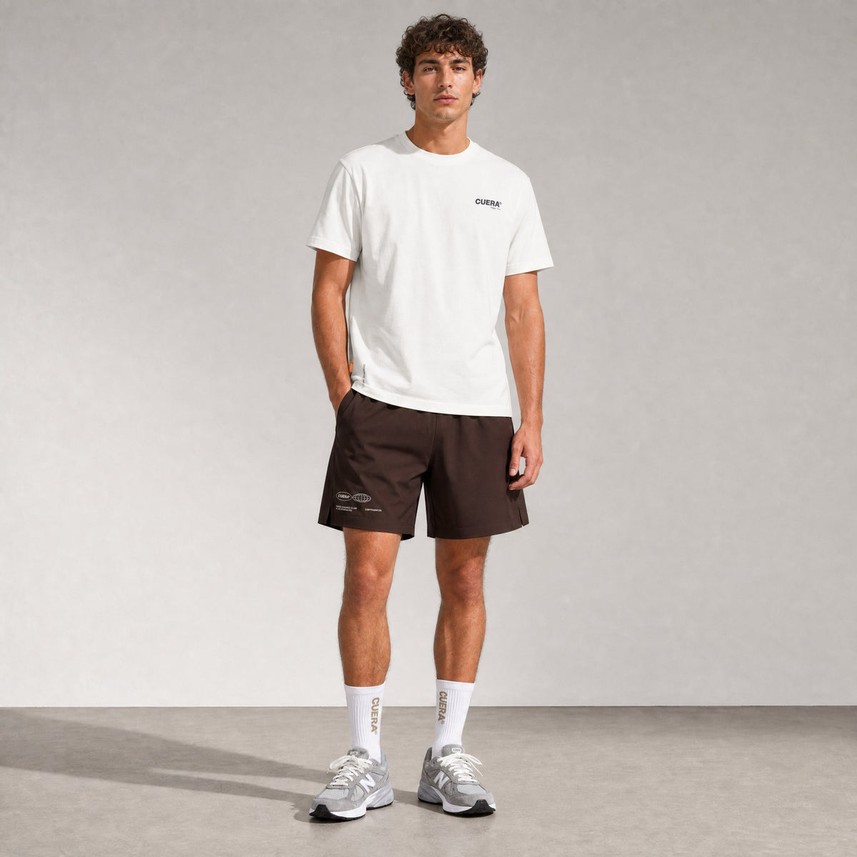 Man wearing Cuera Mens Active Globe Shorts in Dark Brown, front studio view