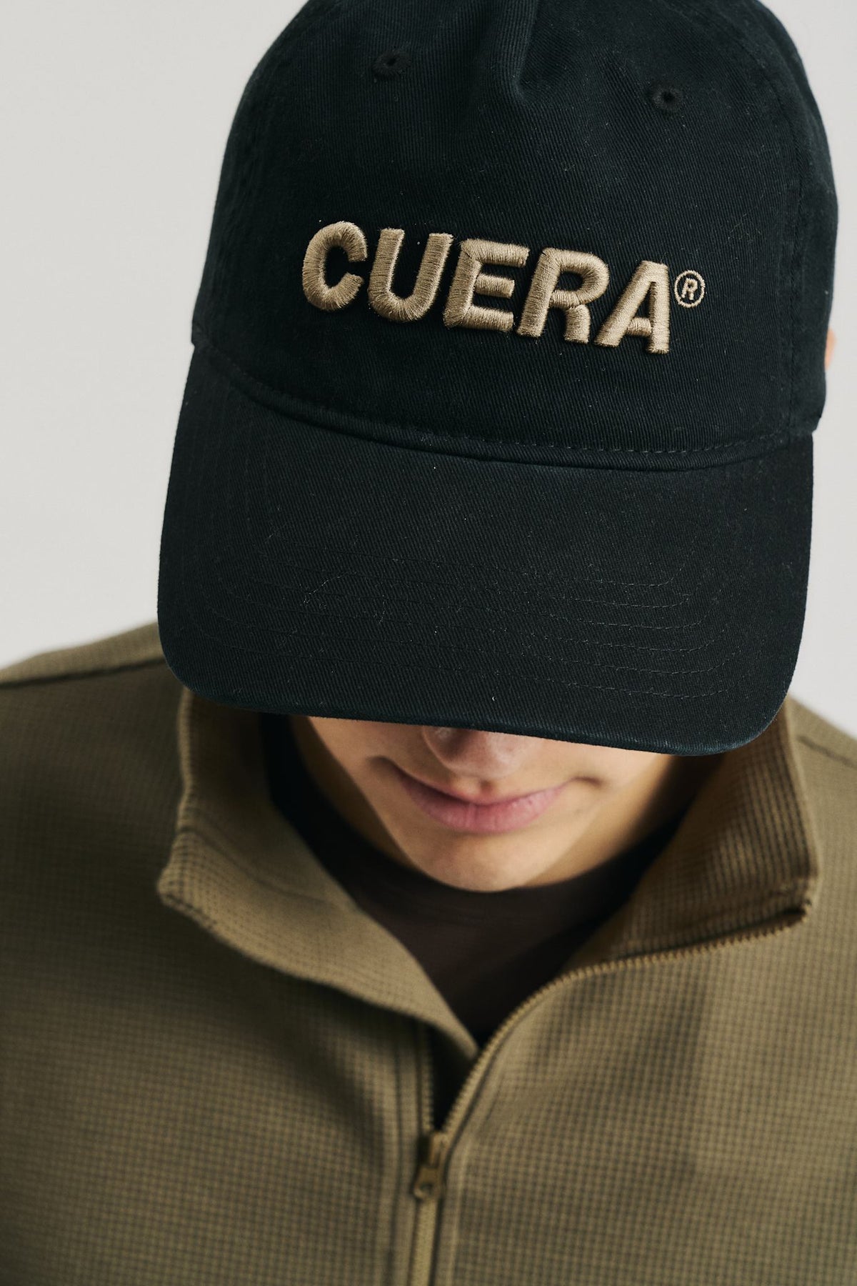 Model wearing Cuera Offcourt Cuera Cap in Black, front studio view