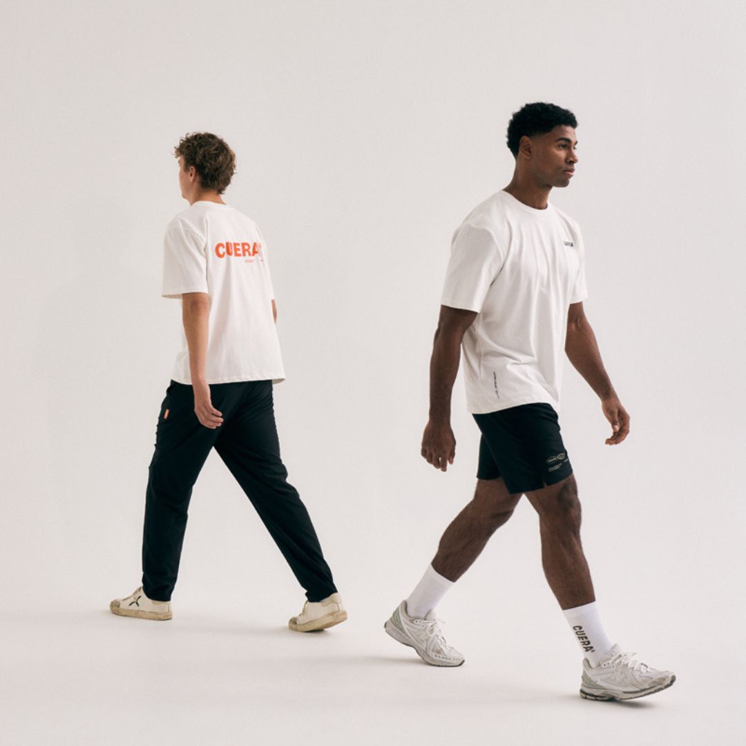 Model wearing Cuera Offcourt Logo T-Shirt in Off White w. Orange, lifestyle action shot on the padel court