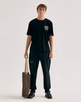 Model wearing Cuera Offcourt WPC T-Shirt in Black, lifestyle action shot on the padel court