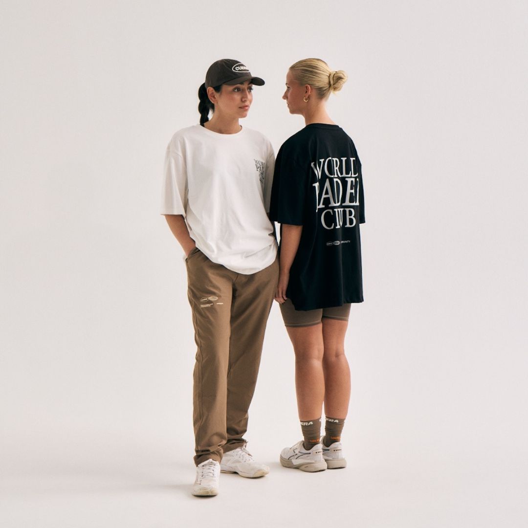 Model wearing Cuera Offcourt WPC T-Shirt in Off White w. Army, lifestyle action shot on the padel court