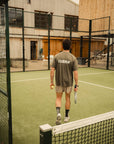 Model wearing Cuera Oncourt Airy Logo T-Shirt in Army, lifestyle action shot on the padel court