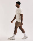 Model wearing Cuera Oncourt Airy Logo T-Shirt in Off White, lifestyle action shot on the padel court