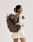 Model wearing Cuera Oncourt Bagpack small in Walnut, front studio view