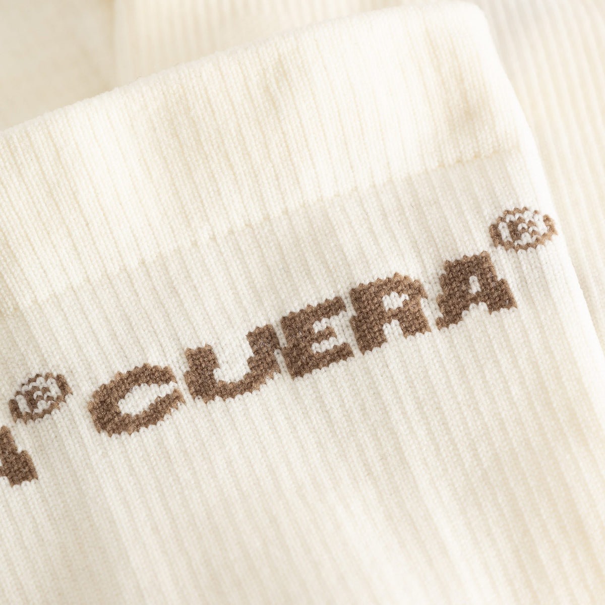 Cuera Oncourt Compression Sleeve in Off White, logo print detail