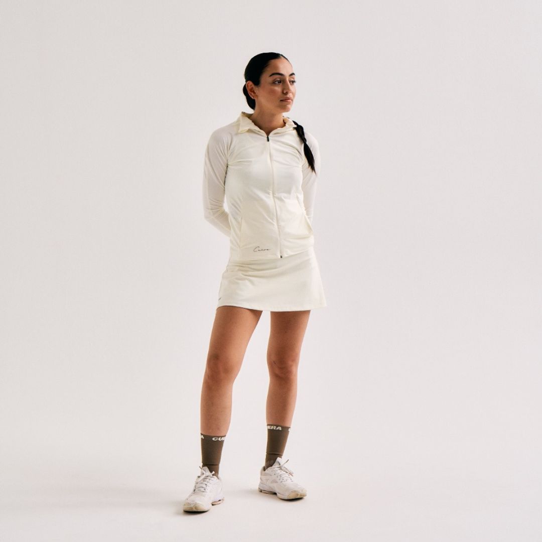 Model wearing Cuera Oncourt Cuera Skirt 2-in-1 in Off White, back studio view
