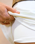Model wearing Cuera Oncourt Cuera Skirt 2-in-1 in Off White, close-up detail on model