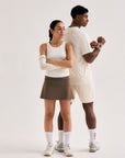 Model wearing Cuera Oncourt Cuera Skirt 2-in-1 in Walnut, lifestyle action shot on the padel court
