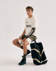 Model with Cuera Oncourt Premium Padel Bag in Black, lifestyle action shot on the padel court