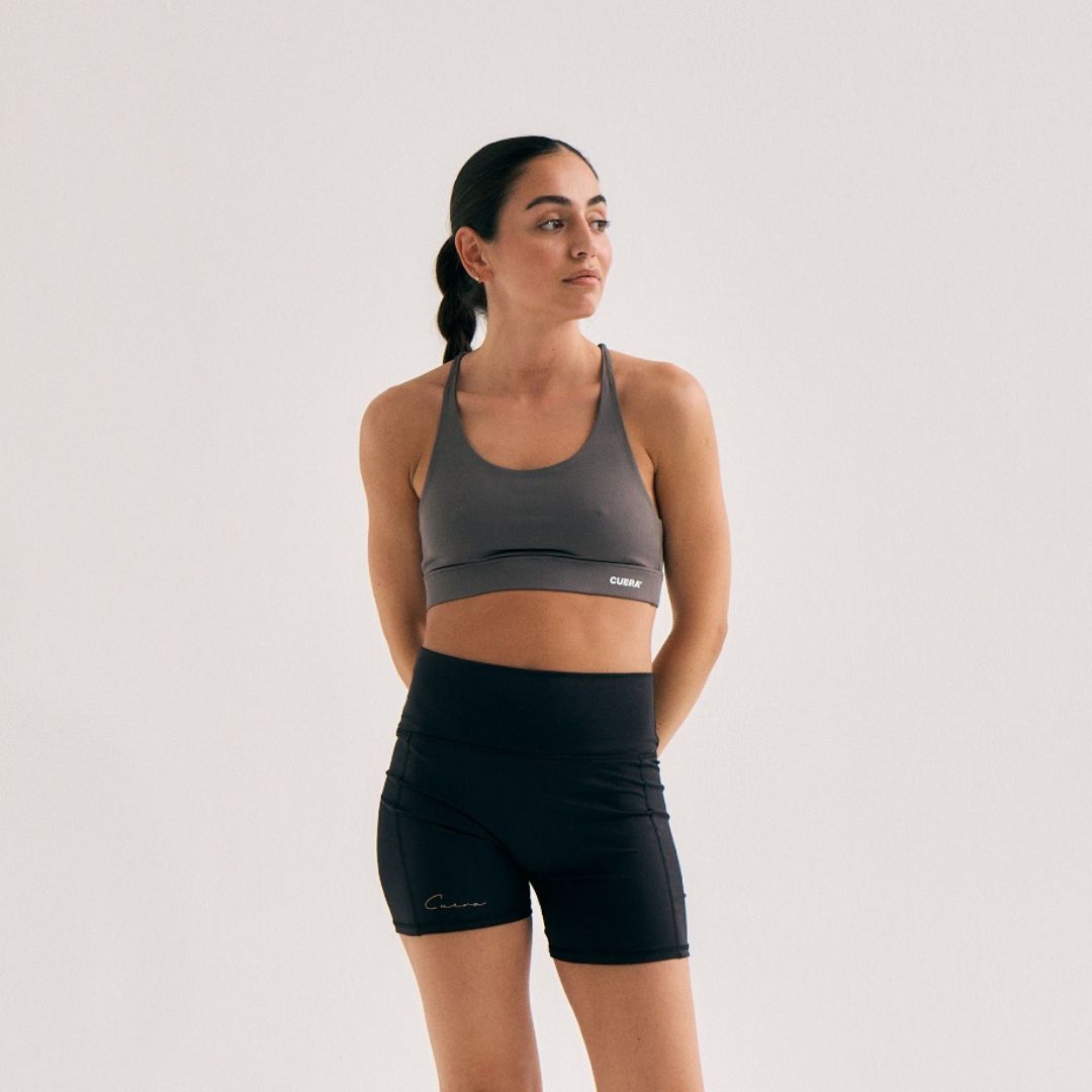 Model wearing Cuera Oncourt Soft Bra Top in Dark Grey, front studio view
