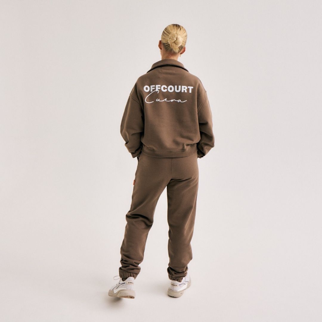 Model wearing Cuera Offcourt Cuera Half Zip Sweat in Walnut, back studio view