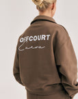 Model wearing Cuera Offcourt Cuera Half Zip Sweat in Walnut, front studio view