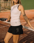 Woman wearing Cuera Women's Active Globe Shorts in Black standing at the padel net
